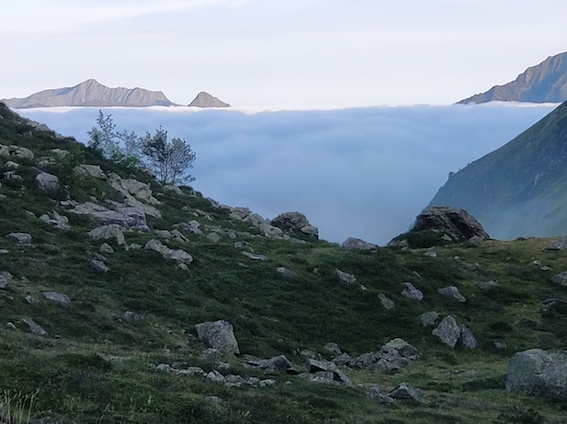 Photo d'un brouillard blanc neige qui recouvre l'horizon duquel dépassent quelques montagnes